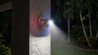 AI-powered spotlight camera deterring intruder at night at a Florida home